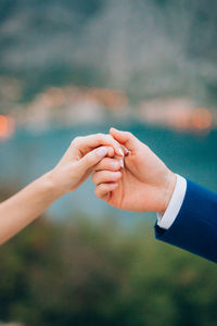 Midsection of couple holding hands