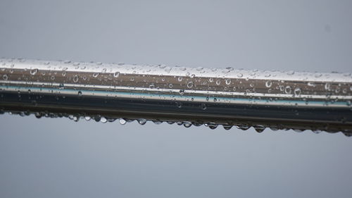 Low angle view of wet bridge against sky during rainy season