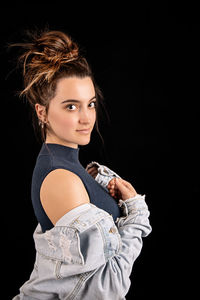 Portrait of a beautiful young woman over black background