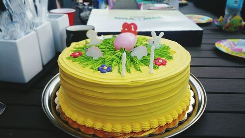 Close-up of yellow birthday cake on table
