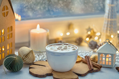 Seasonal winter beverage on christmas decorated windowsill. chocolate drink with marshmallow