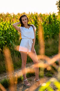 Portrait of young woman standing against plants