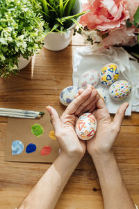 Cropped hands of woman holding heart shape on table