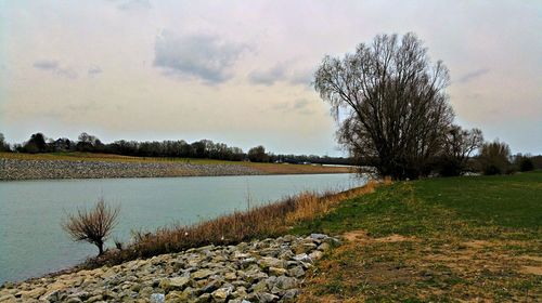 Scenic view of lake against cloudy sky