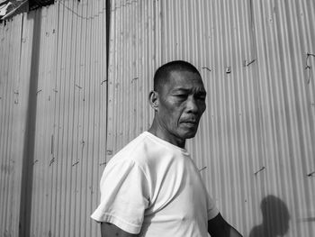 Portrait of man standing against wall