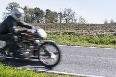 Blurred motion of man riding motorcycle on road