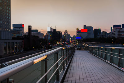 City street and buildings against sky during sunset