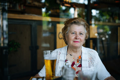 Portrait of woman drinking glasses on table at restaurant