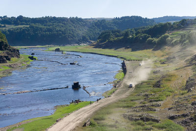 Scenic view of river amidst trees against sky