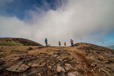 People on mountain against sky