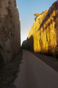 Road amidst rocks against clear sky