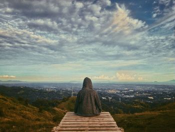 Woman by sea against sky