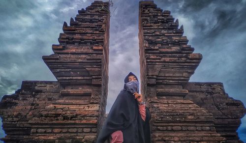 Low angle view of man outside temple against sky