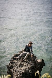 High angle view of woman sitting on rock