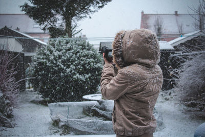Woman photographing through camera during winter