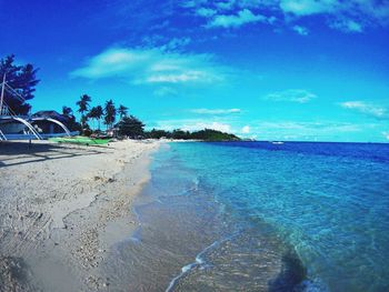 Scenic view of beach against blue sky