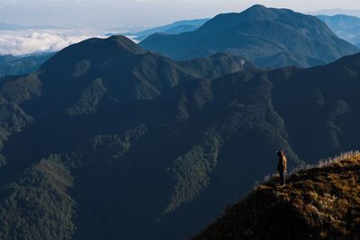 Scenic view of mountains. standing at the edge of a cliff.