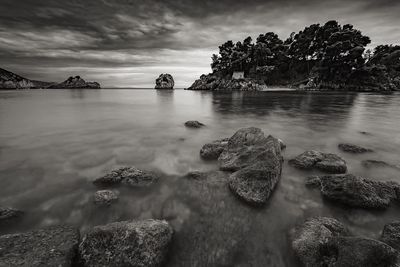 Scenic view of rocks in sea against sky