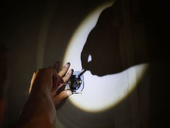 Cropped hands of man working against wall