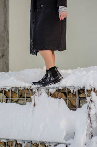 Low section of woman standing on snow covered landscape