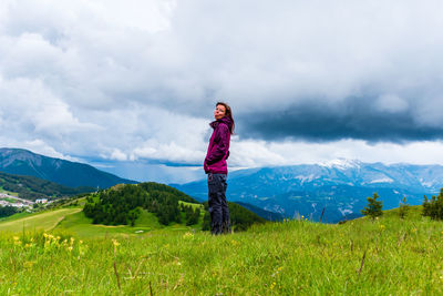 A young female hiker on a break during a hike on a cloudy summer day in the french alps