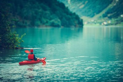 Rear view of man kayaking in lake