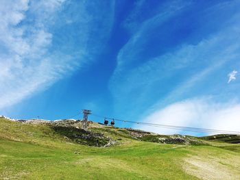 Low angle view of wind turbines against sky