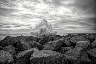 Rocks by sea against sky