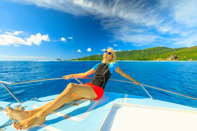 Woman in boat on sea against sky