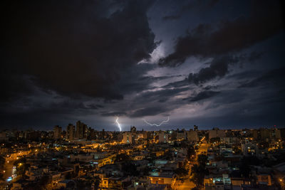 Illuminated buildings in city against sky at night