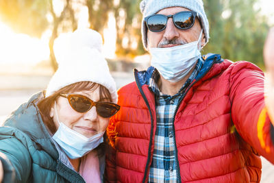Portrait of senior couple wearing mask standing outdoors