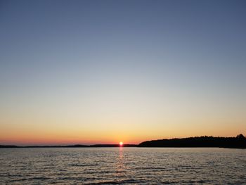 Scenic view of sea against clear sky during sunset