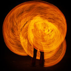 Full length of illuminated man standing against black background