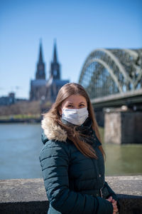 Young woman standing on bridge in city