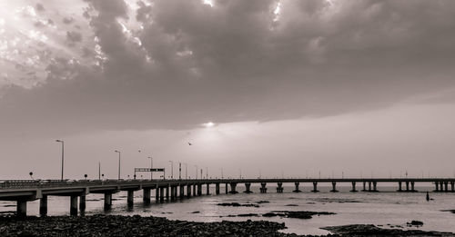 Pier over sea against sky during sunset