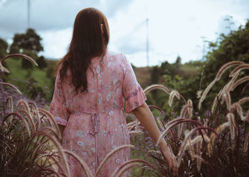 Rear view of woman standing on field