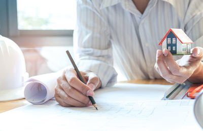 Midsection of businessman writing in office