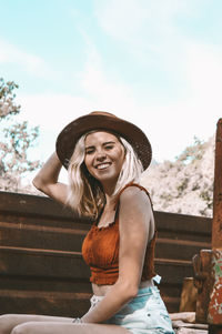 Portrait of beautiful young woman sitting outdoors