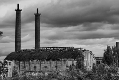 Old factory against cloudy sky