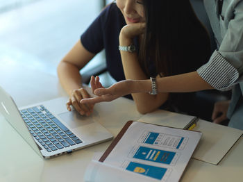 Midsection of businesswomen brainstorming in office