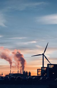 Smoke emitting from chimneys against sky during sunset