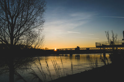 Scenic view of river against sky at sunset