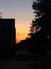 Silhouette buildings against sky at sunset