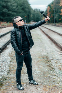 Full length of young man standing on railroad track