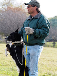 Man with dog standing on field
