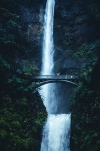 Person standing on benson bridge against multnomah falls