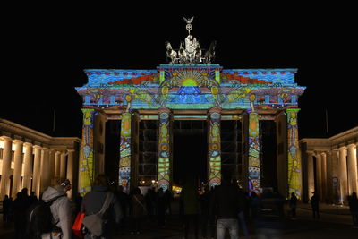 Group of people in front of illuminated building at night