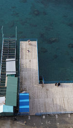 High angle view of couple standing on pier at sea