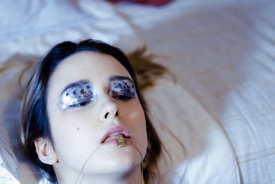 Portrait of young woman lying on bed