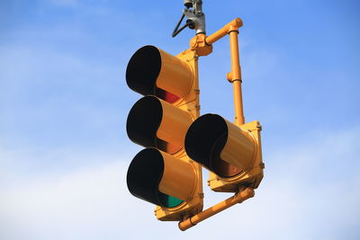 Low angle view of road signal against sky